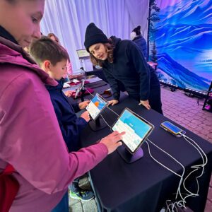 Guests at Northstar's Winter Wonders, choosing designs on tablets for their custom patches.